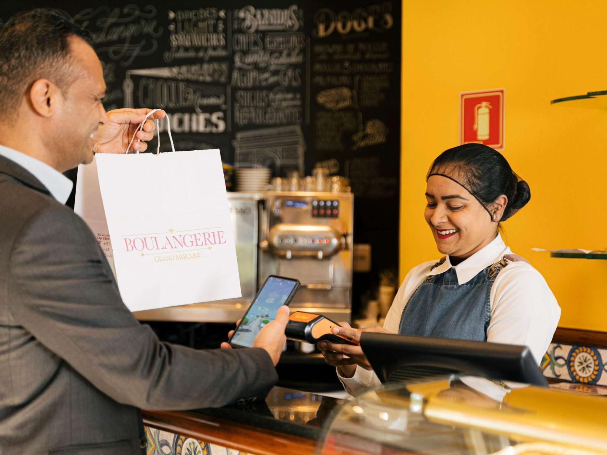 Grand Mercure Sao Paulo Ibirapuera Εξωτερικό φωτογραφία A customer using a mobile phone to make a payment